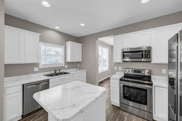 kitchen with stainless steel appliances, a center island, and white cabinets