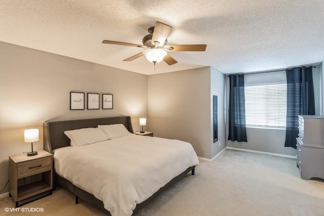 bedroom featuring baseboards, ceiling fan, a textured ceiling, and light colored carpet