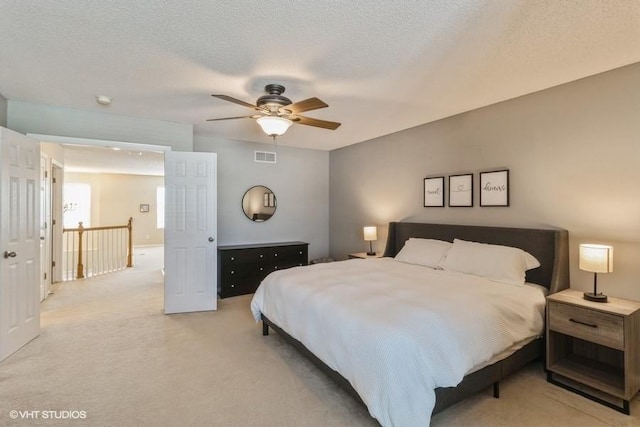 bedroom featuring light carpet, visible vents, and ceiling fan