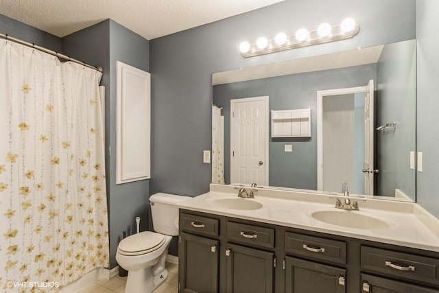 bathroom featuring double vanity, tile patterned flooring, toilet, and a sink