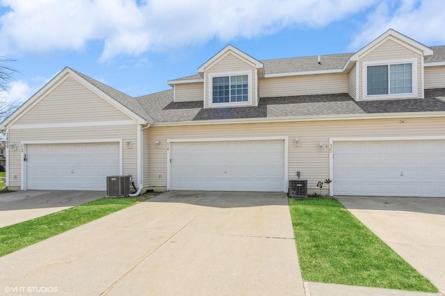 multi unit property featuring roof with shingles, central AC, and concrete driveway