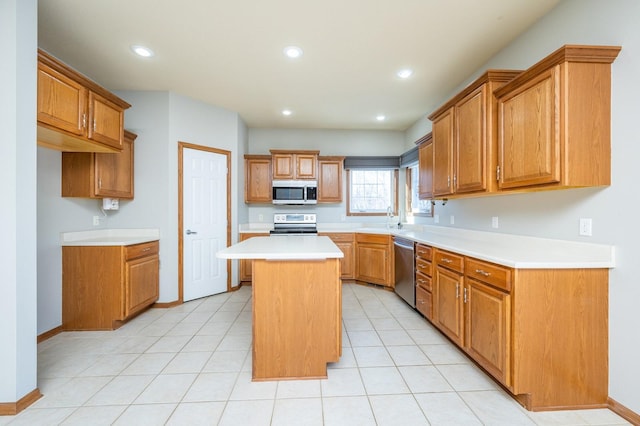 kitchen featuring light countertops, appliances with stainless steel finishes, brown cabinets, and a center island