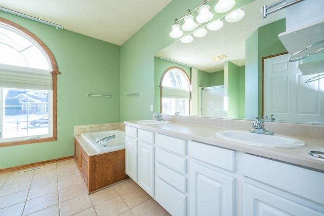 bathroom with double vanity, a garden tub, tile patterned flooring, a shower stall, and a sink