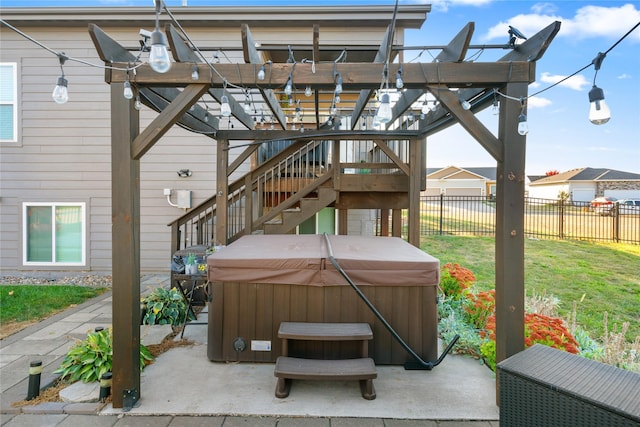 view of patio featuring stairway, fence, and a hot tub