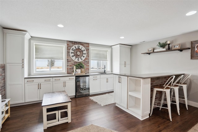 kitchen with white cabinets, plenty of natural light, beverage cooler, and open shelves