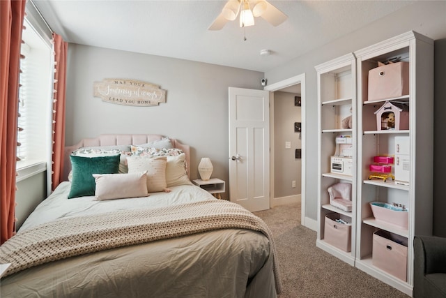 bedroom with a ceiling fan, baseboards, multiple windows, and carpet flooring