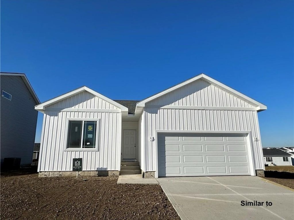 modern farmhouse with entry steps, driveway, board and batten siding, and an attached garage