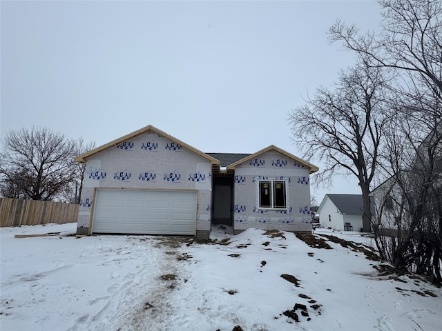 property under construction with fence and an attached garage