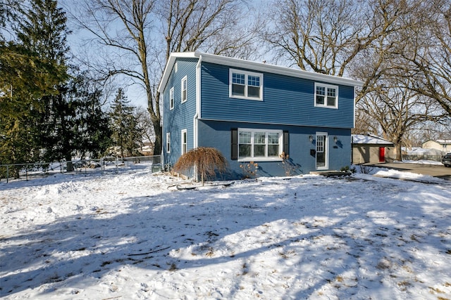 colonial home featuring brick siding and fence