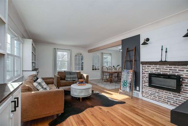 living area featuring light wood-style flooring and a fireplace