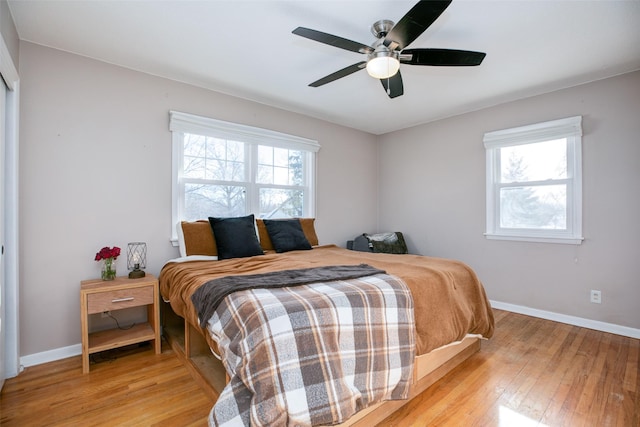 bedroom featuring a ceiling fan, baseboards, and light wood finished floors