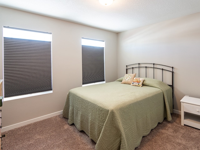 bedroom with baseboards and light colored carpet