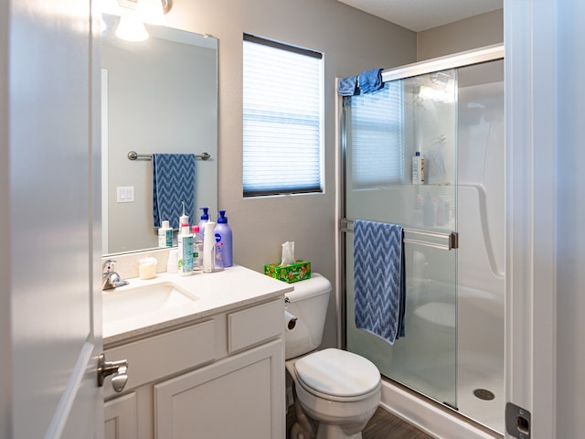 full bath with a shower stall, toilet, vanity, and wood finished floors