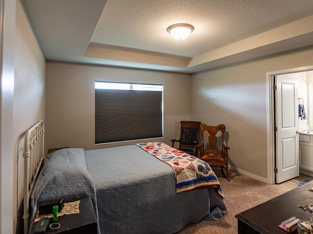 bedroom featuring baseboards, carpet flooring, a textured ceiling, and a tray ceiling