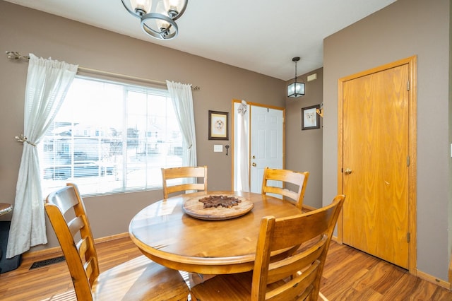 dining space featuring light wood-style floors and baseboards