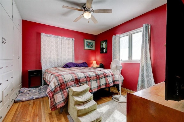 bedroom with light wood-style floors and a ceiling fan