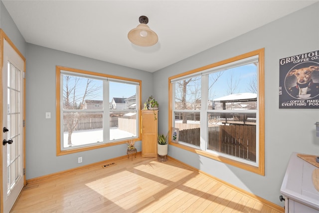 interior space with light wood finished floors, visible vents, and baseboards