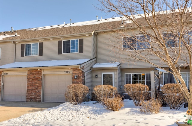 view of front of home featuring stone siding, driveway, and an attached garage