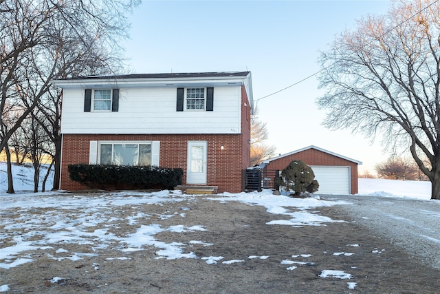 colonial home with a garage, an outbuilding, and brick siding