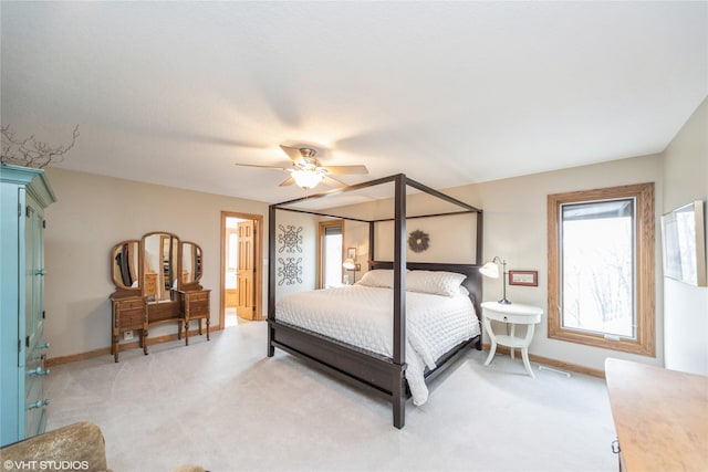 bedroom featuring light carpet, ceiling fan, and baseboards