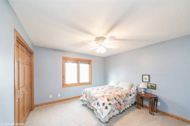 bedroom featuring ceiling fan, a textured ceiling, baseboards, and a closet