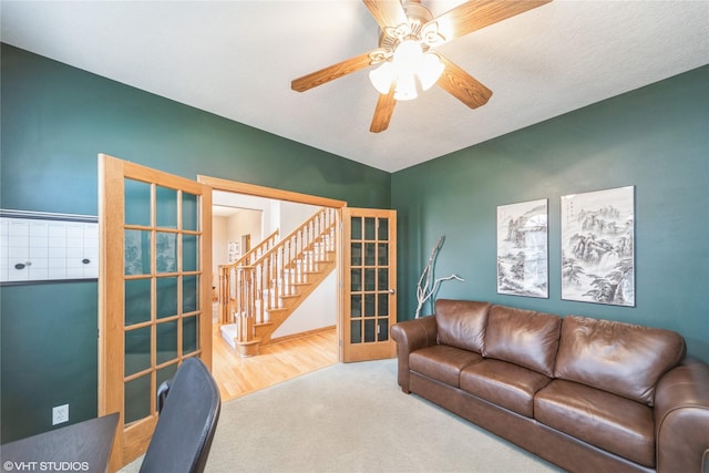 carpeted living room featuring a ceiling fan and french doors