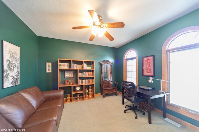 office space with light carpet, visible vents, baseboards, and a ceiling fan