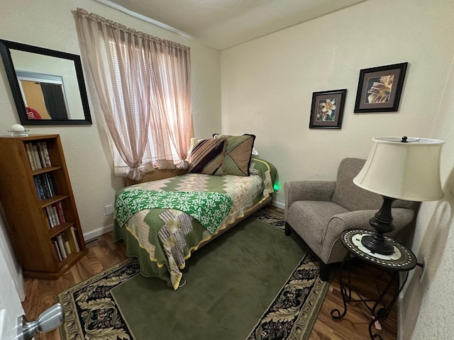 bedroom featuring wood finished floors and baseboards