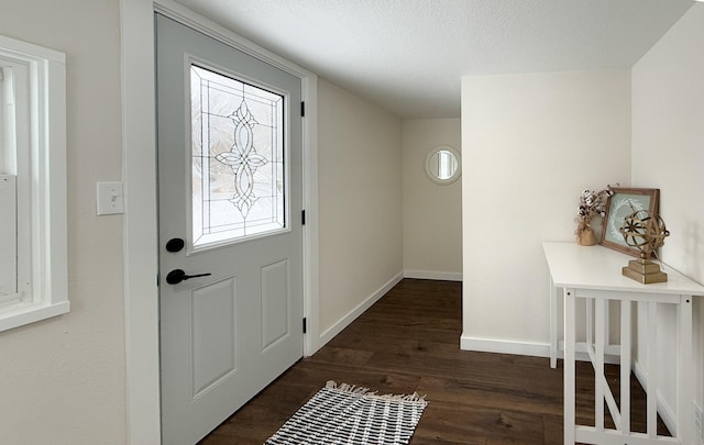 entryway with a textured ceiling, dark wood-style flooring, and baseboards