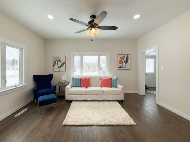 living area featuring dark wood-type flooring and a healthy amount of sunlight