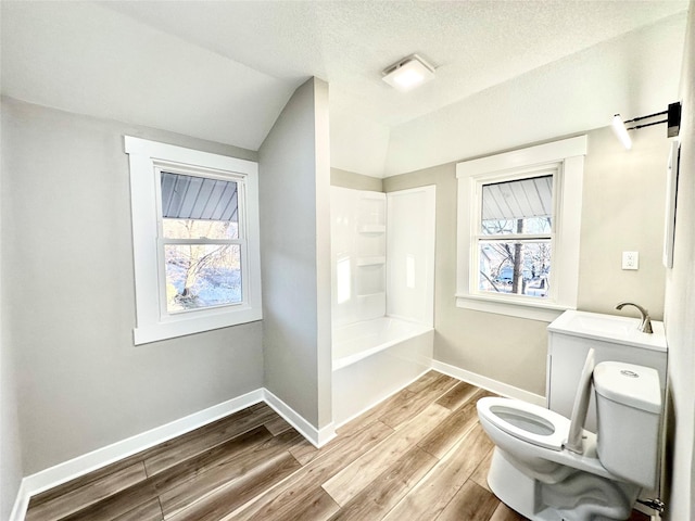 bathroom featuring plenty of natural light, wood finished floors, toilet, and baseboards