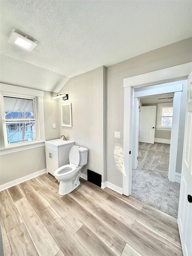 bathroom featuring toilet, visible vents, wood finished floors, and vanity