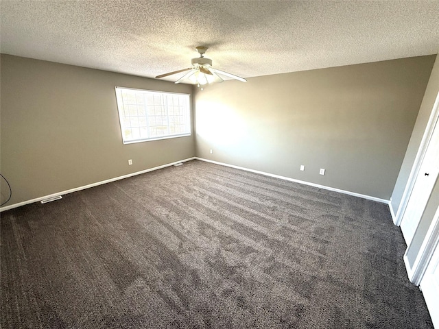 spare room with dark carpet, a ceiling fan, and baseboards