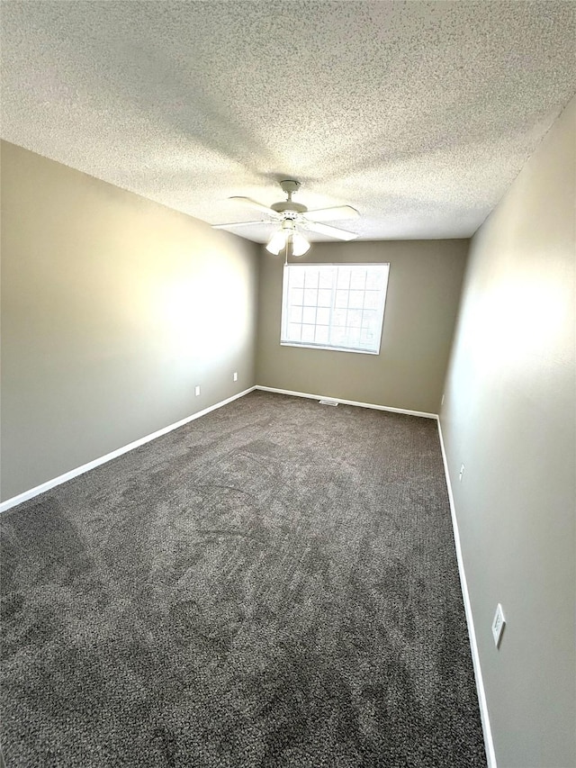 carpeted spare room with ceiling fan, baseboards, and a textured ceiling