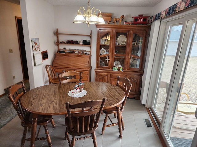 dining area featuring an inviting chandelier, light tile patterned floors, and visible vents