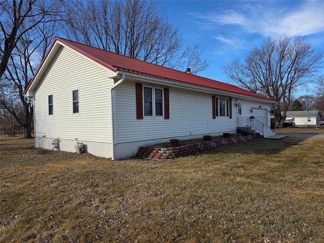 view of side of property with crawl space, metal roof, a lawn, and an attached garage