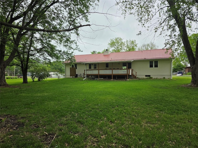 4655 NE 41st Ave, Des Moines, IA 50317 - back of house with a lawn, a chimney, metal roof, and a deck