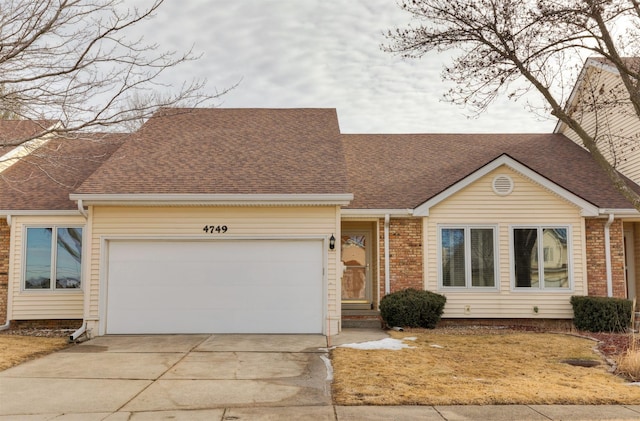 ranch-style house featuring a garage, brick siding, driveway, and a shingled roof