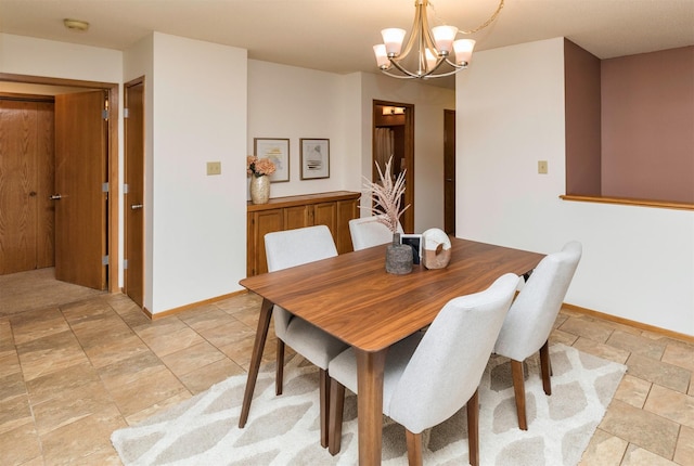 dining area featuring baseboards and a chandelier