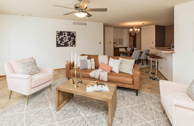 living room featuring ceiling fan with notable chandelier and visible vents