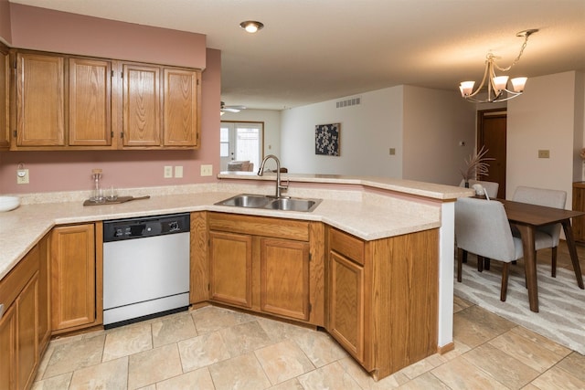 kitchen featuring dishwasher, a peninsula, light countertops, pendant lighting, and a sink