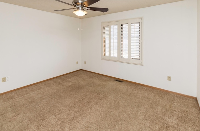 empty room with baseboards, visible vents, ceiling fan, and carpet flooring