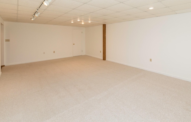 carpeted spare room featuring rail lighting, a drop ceiling, baseboards, and recessed lighting