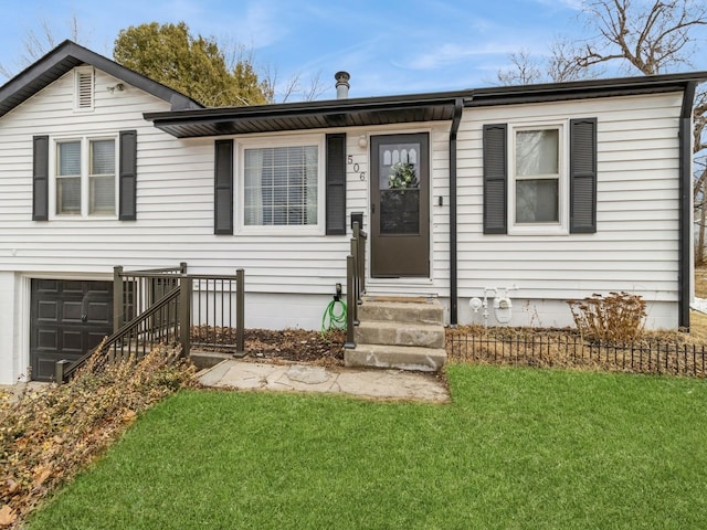 view of front facade featuring entry steps, a front yard, and a garage