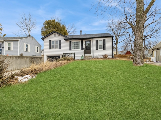 view of front of house featuring entry steps, fence, and a front yard