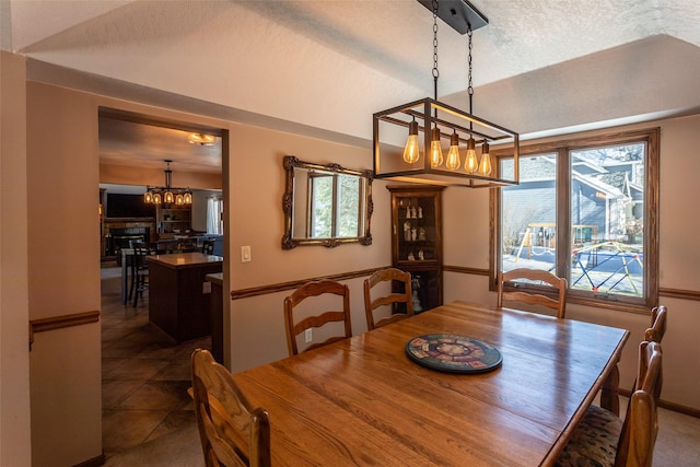 dining space with a textured ceiling and dark tile patterned floors