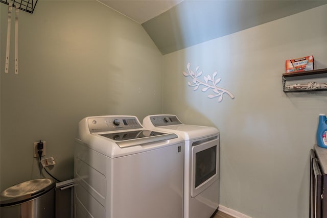 clothes washing area featuring laundry area, baseboards, and washer and dryer