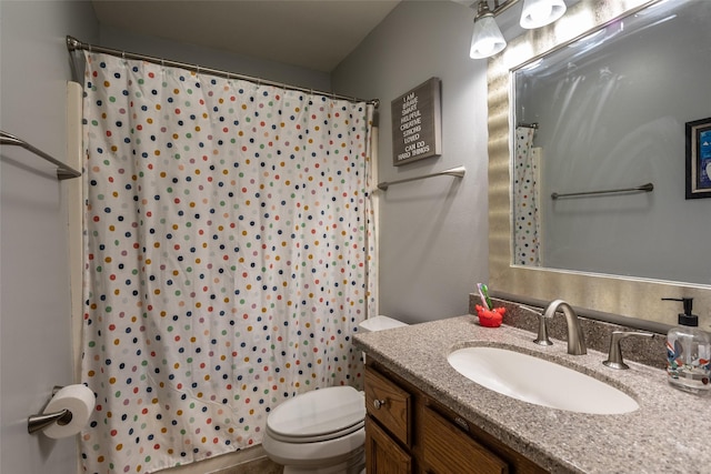 bathroom with curtained shower, vanity, and toilet