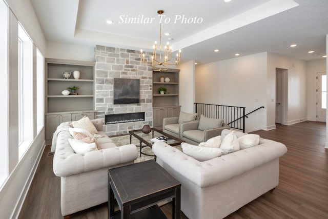 living area featuring a fireplace, dark wood finished floors, recessed lighting, a raised ceiling, and baseboards