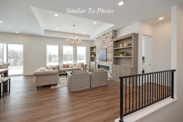 2646 SE Steele Dr, Waukee, IA 50263 - living area with a chandelier, dark wood-style flooring, recessed lighting, a fireplace, and baseboards